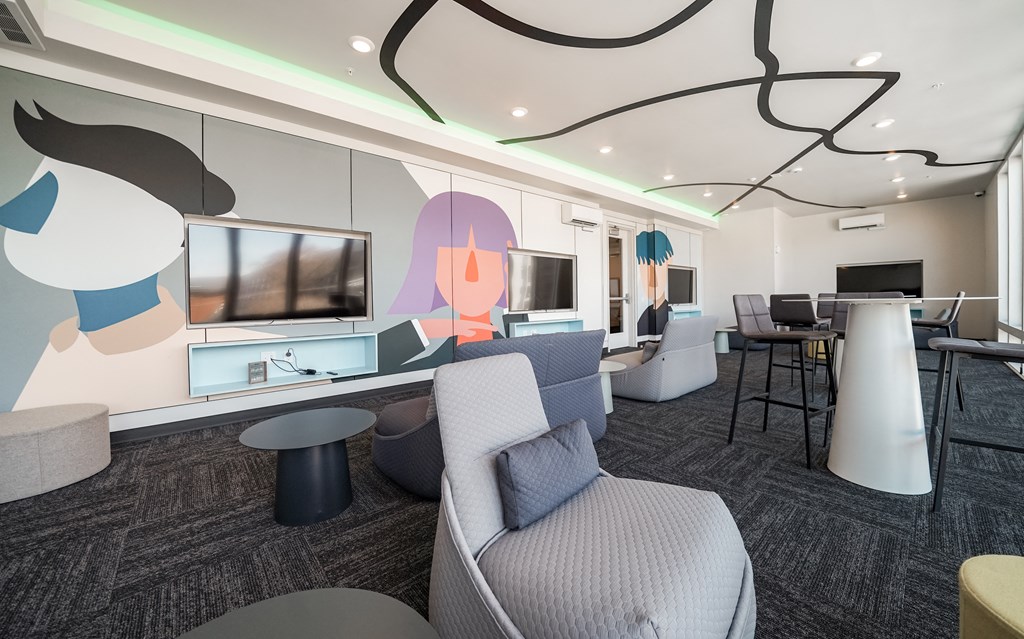 a lounge area with couches and chairs and a television