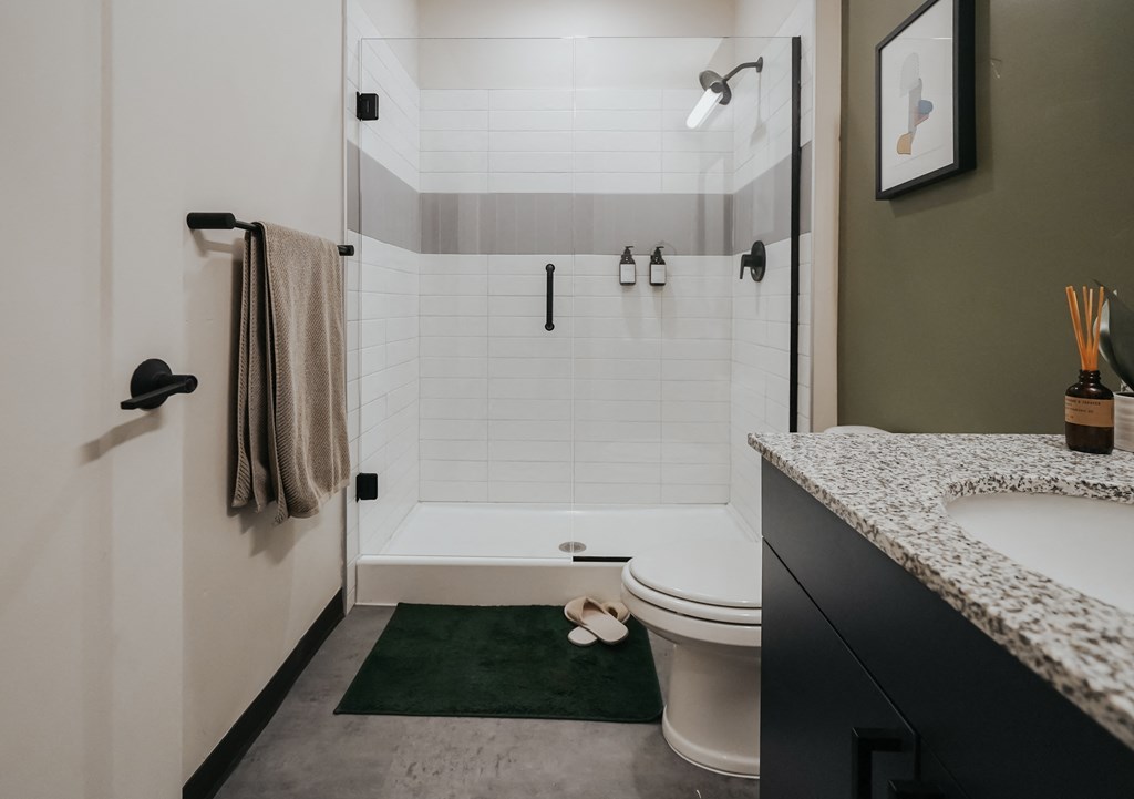 a bathroom with a shower and a sink and a toilet