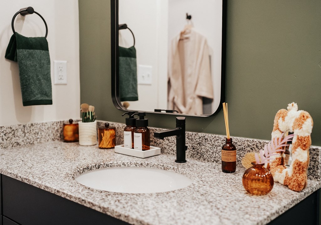 a bathroom counter with a sink and a mirror