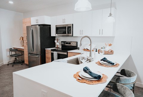 a kitchen with a white counter top and a black refrigerator