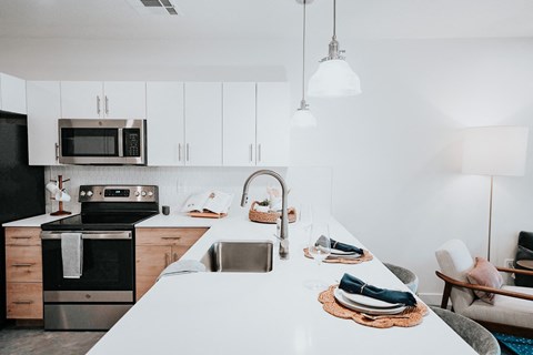 a kitchen with a white counter top and a sink