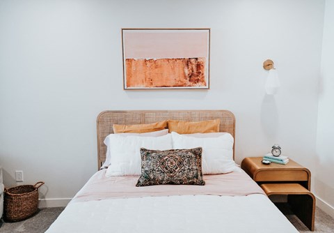 a bedroom with a bed with a pillow and a painting on the wall