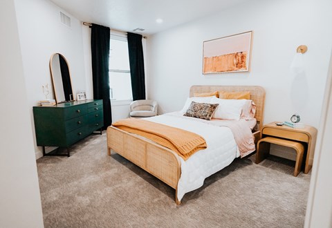 a bedroom with a bed and a dresser and a window