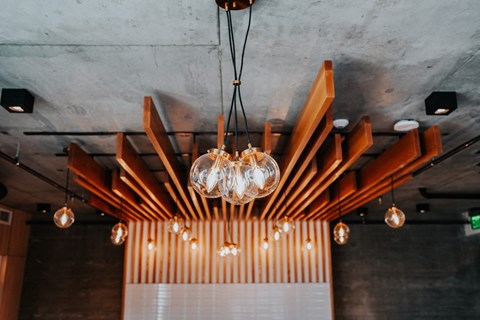a chandelier with lights hanging from a ceiling with wooden beams