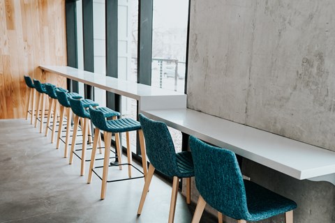 a row of green chairs in front of a marble bar