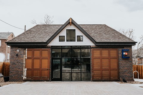 the front of a garage with two wood garage doors