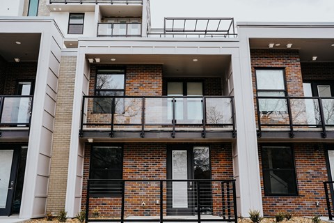 an exterior view of a brick apartment building with a balcony