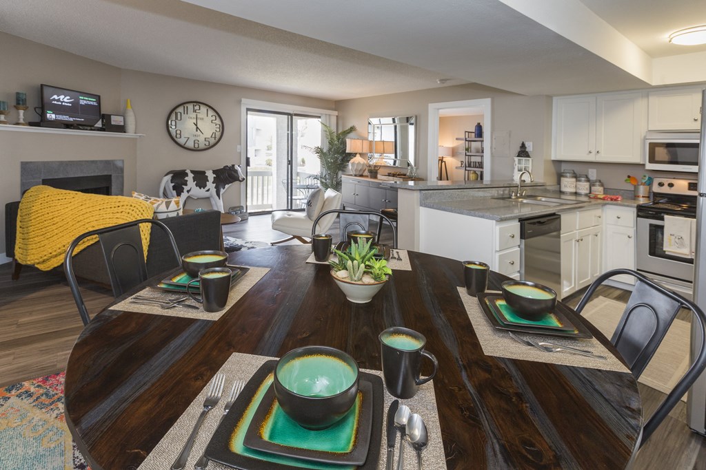 a kitchen and living room with a table and chairs