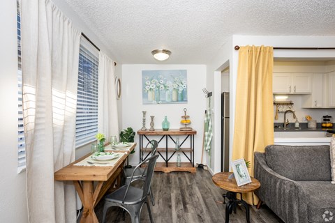 A dining area with a table set for two and a couch.