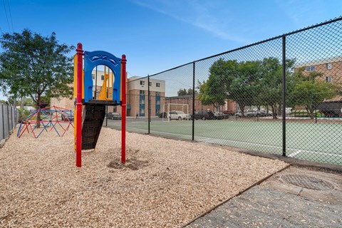a playground with a swing set and a tennis court