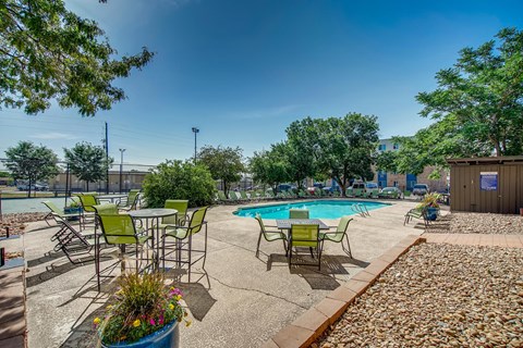 our apartments have a pool and patio with chairs and tables