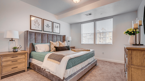 A bedroom with a large bed, a dresser, and a nightstand.