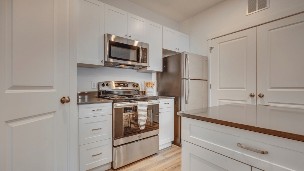 A kitchen with white cabinets and stainless steel appliances.