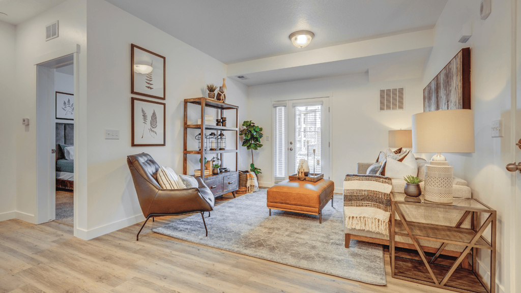 A living room with a chair, a table, and a rug.