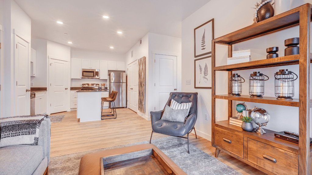 A modern living room with a grey armchair and a wooden coffee table.