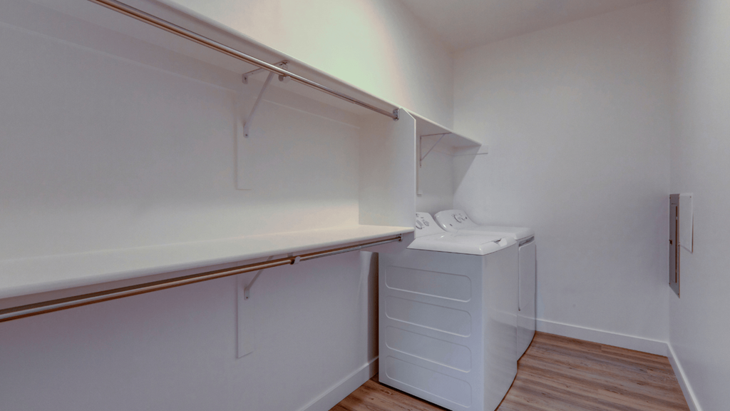 A white laundry room with a washer and dryer.