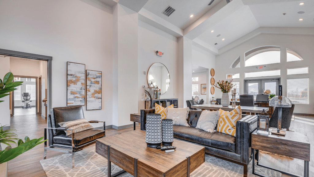 A living room with a black sofa, a wooden coffee table, and a mirror on the wall.