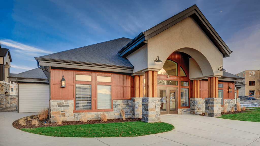 A building with a stone wall and a red door.