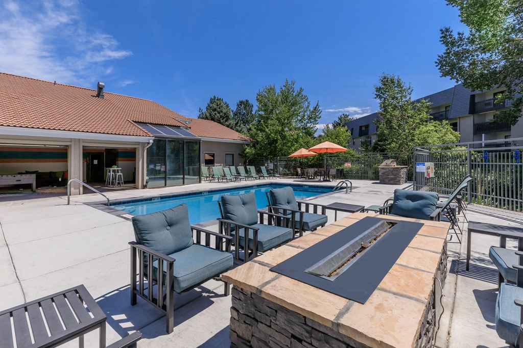 A patio with a table, chairs, and a pool.