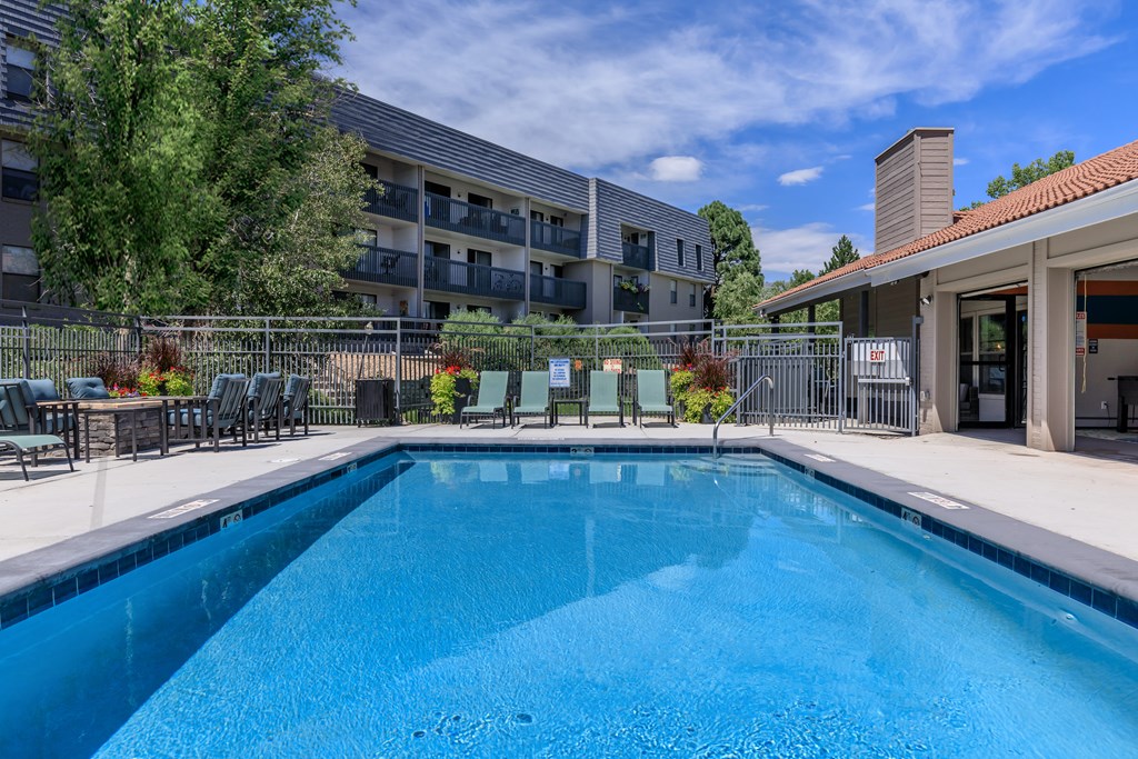 A swimming pool in a residential area with a building in the background.