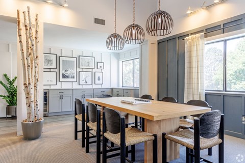 A dining room with a long table and chairs.