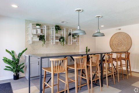 A kitchen with a table and chairs and a plant.