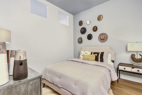 A bedroom with a bed, nightstand, and wall decor.