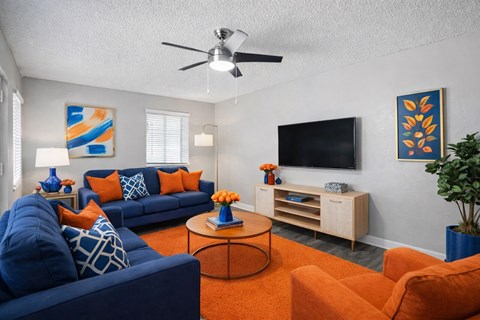 A living room with a blue couch and orange accents.