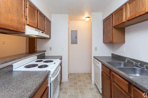 A kitchen with white appliances and wooden cabinets.