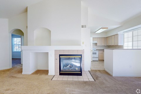 A living room with a fireplace and a painting on the wall.