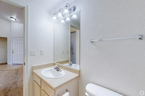 A bathroom with a sink, mirror, and towel rack.