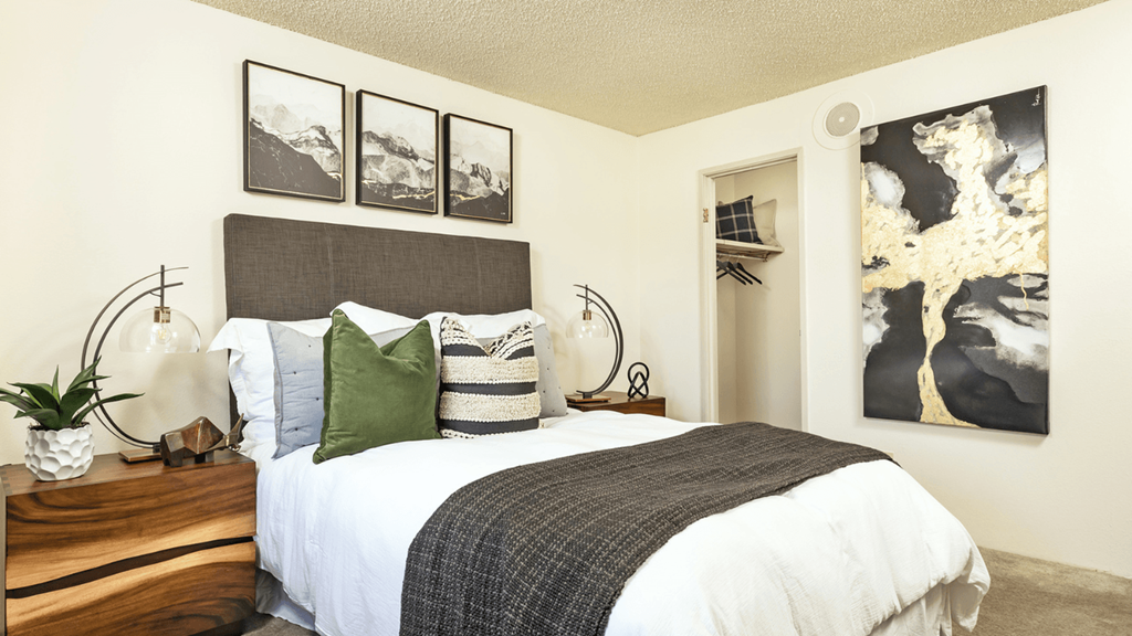 a bedroom with a bed and pictures on the wall