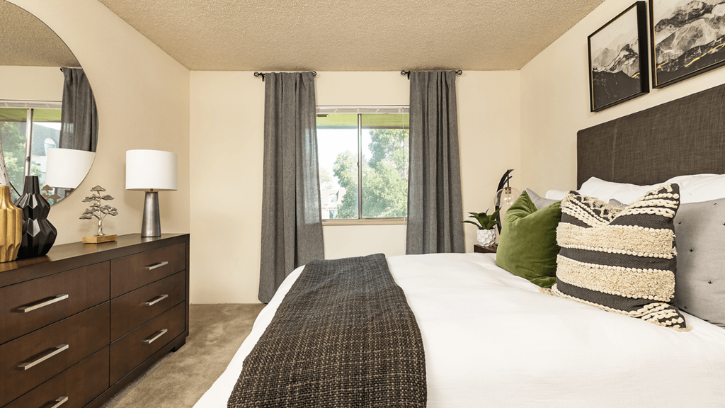 a bedroom with a bed and a dresser and a window