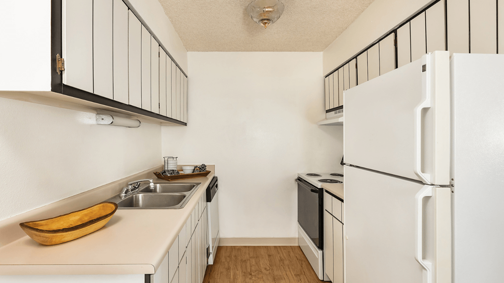 an empty kitchen with a sink and a refrigerator