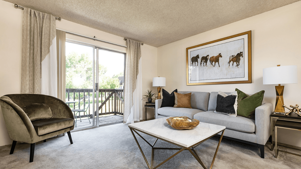 a living room with a couch and a coffee table and a balcony