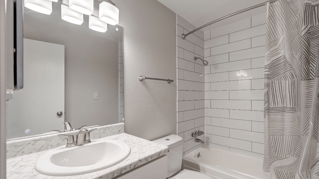a bathroom with a white sink and a shower and a tub