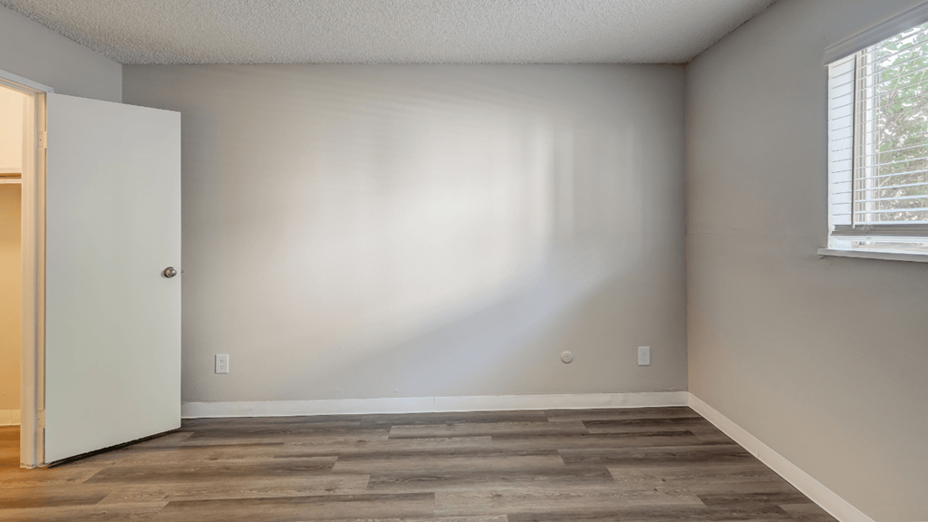 an empty room with a door and a window