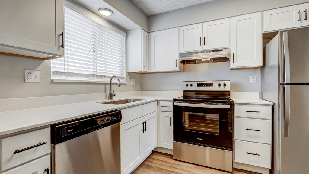 a kitchen with white cabinets and stainless steel appliances