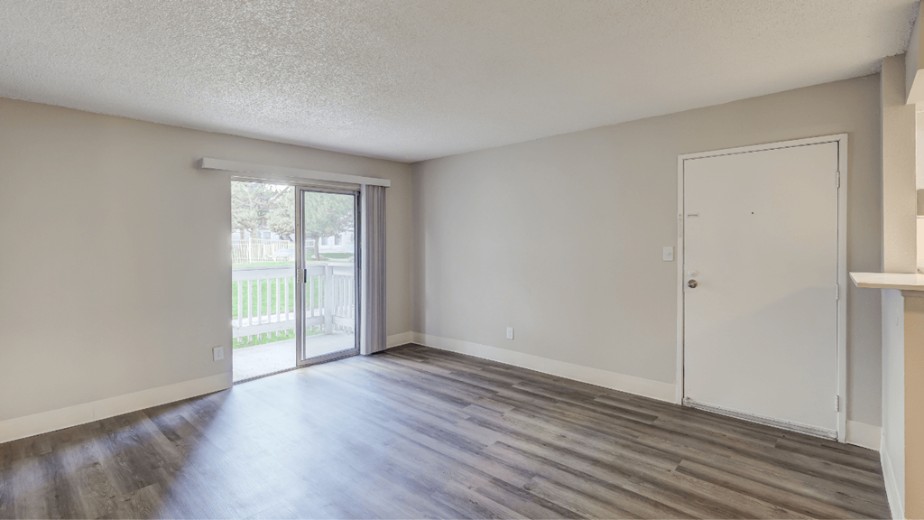 an empty living room with a door to a patio