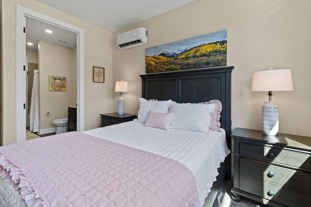 a bedroom with a large bed and a painting on the wall