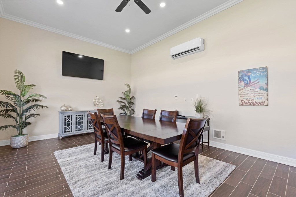 a dining room with a table and chairs and a tv