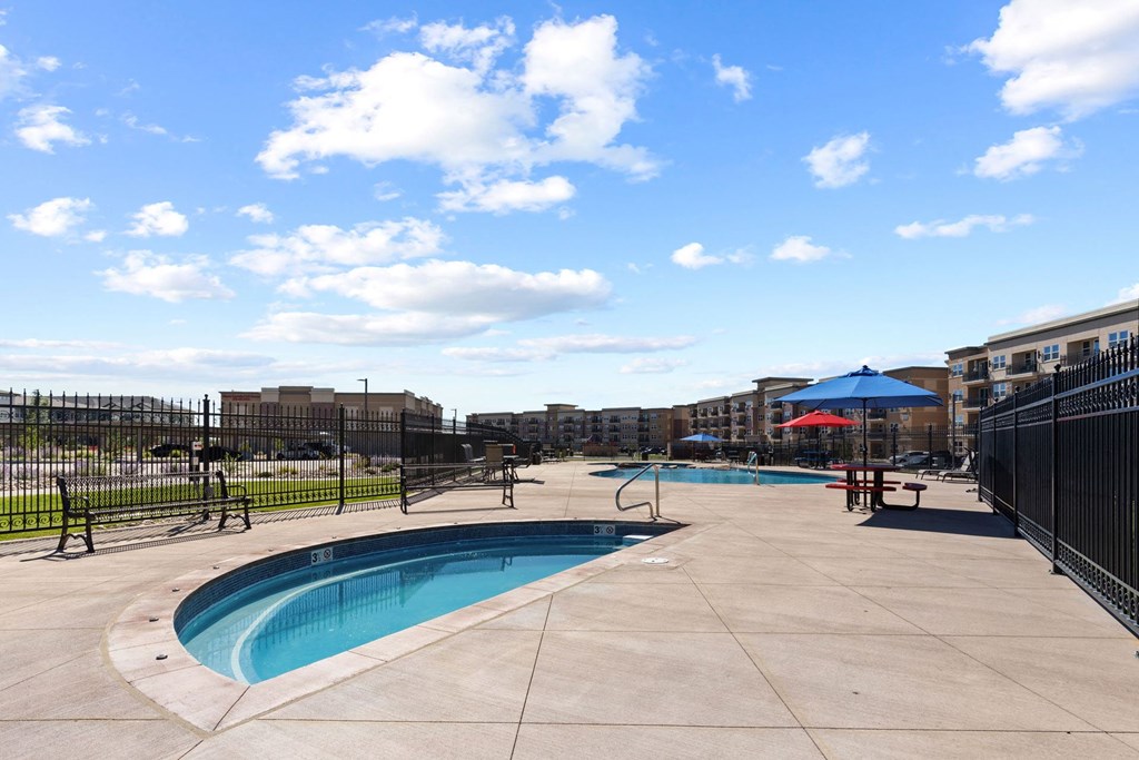a swimming pool with a fence around it and a building in the background