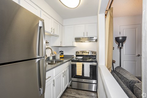 A modern kitchen with a stainless steel refrigerator and a stove top oven.