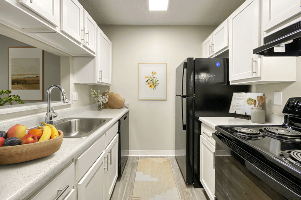 a kitchen with black appliances and white cabinets