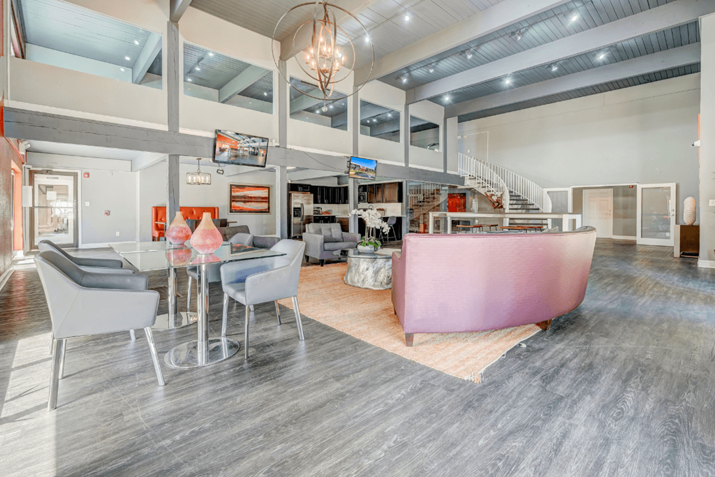 a living room with a table and chairs and a pink couch