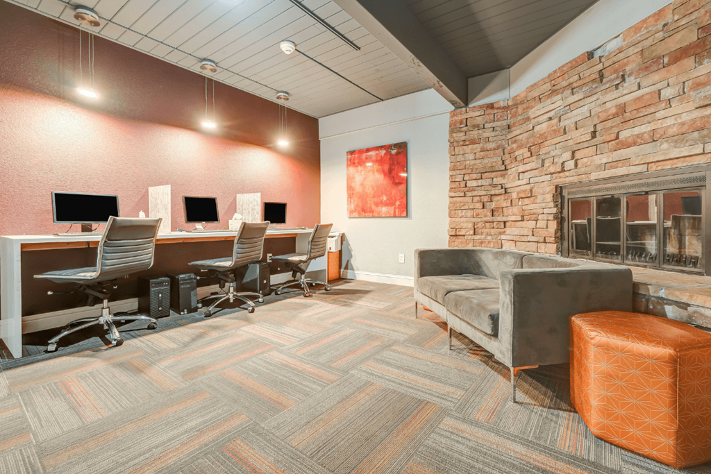 a conference room with desks and chairs and a fireplace