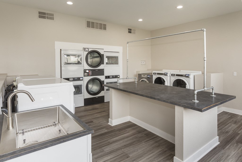 a laundry room with a sink and washer and dryer and a counter top