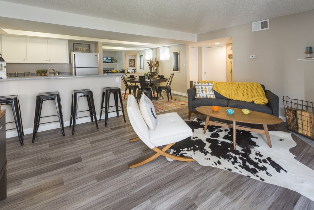 a living room with a couch and a table and a kitchen