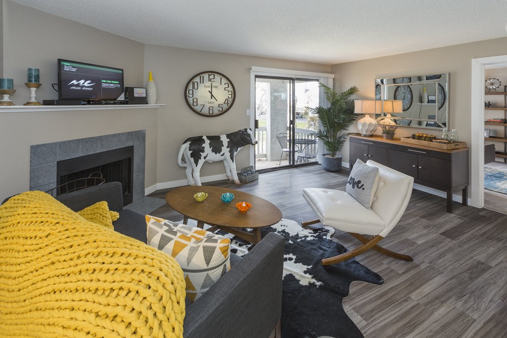 a living room with a fireplace and a cow clock on the wall