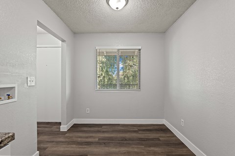 A room with a window and wooden floors.